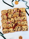 Sliced festive loaf cake platter with figs and oranges on a white background